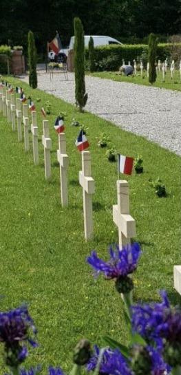 Articles de L'EST RÉPUBLICAIN du 17 mai 2020 BRAVO MR BUISSON A 93 ans, il achète des fleurs et fleurit, seul, les tombes des soldats Il s’est mis à quatre pattes dans le cimetière pour poser ses bégonias et ses petits drapeaux au millimètre, près des tombes des soldats. À 93 ans, Émile Buisson a organisé sa propre commémoration du 8-Mai. « Covid ou pas, il fallait bien honorer nos petits gars, morts pour notre liberté. » il est allé avec sa cagnotte personnelle acheter 160 bégonias roses et a passé la journée entière à planter, au millimètre, ses fleurs et ses alignements de petits drapeaux. Quand le maire est arrivé avec deux adjoints, ce 8-Mai, au cimetière de Morvillars, pour déposer la traditionnelle gerbe, Émile Buisson était encore à quatre pattes : il posait des petits crochets, un à un, pour que le vent ne couche pas les fleurs. Seul, à 93 ans, et incognito. Vêtu d’une chemise à carreaux et d’un chapeau de paille. Pourtant, c’est bien son cœur d’ ancien combattant, membre du Souvenir français , qui était à l’œuvre. Émile Buisson a fleuri ainsi des centaines de tombes de soldats de la nécropole internationale de Morvillars. Dans l’isolement total.« Je ne pouvais pas les laisser seuls, les p’tits gars qui se sont battus pour nous, c’est normal non ? » dit-il, avec simplicité. Il pensait que personne ne viendrait pour eux au cimetière en raison du confinement. « Quand j’ai vu les élus arriver, ça m’a suffoqué » La surprise, totale. « Covid-19 ou pas, il fallait honorer la mémoire de ceux qui sont morts pour notre liberté. » Émile Buisson sait de quoi il parle. Il a été combattant au Vietnam « et tout partout ».Depuis la libération d’Ecurcey, un éclat d’obus tient l’os d’une de ses jambes. « Quand on est venu me chercher, je portais une pancarte “À amputer”. » Il a échappé à la fatale opération, mais chaque jour, depuis 76 ans, la plaie coule. « Tous les jours, une infirmière vient changer mon pansement. »